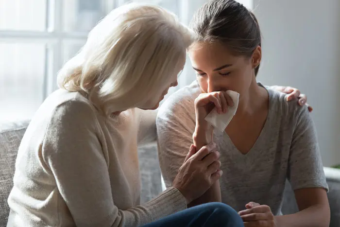 mom consoling her young adult daughter - loved one