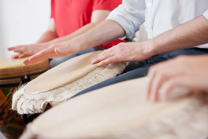 closeup cropped shot of group of people drumming - drumming therapy