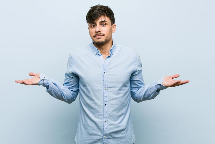 young man standing in questioning stance with arms out to his side and palms up - dry drunk