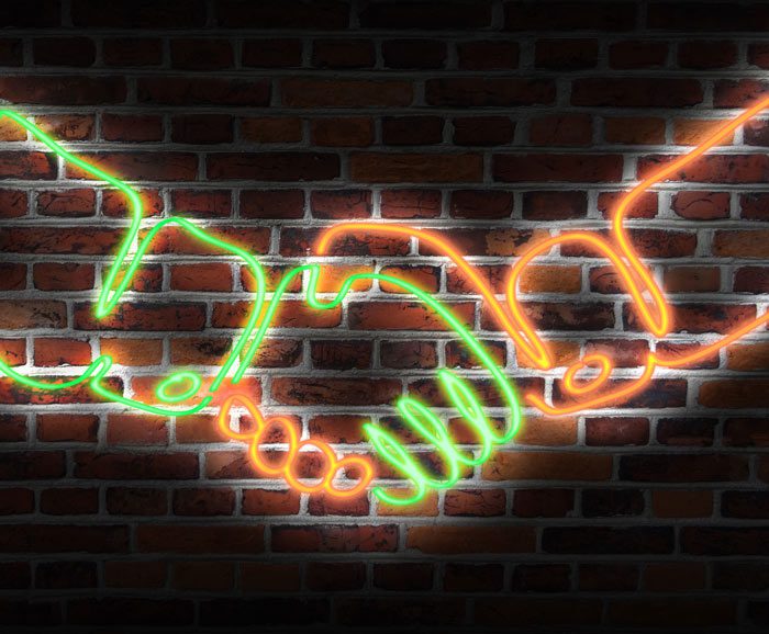 digital illustration of neon sign showing two hands shaking each other against a brick background - partnership