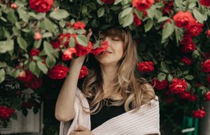 woman smelling roses, flowers, happy, recovery