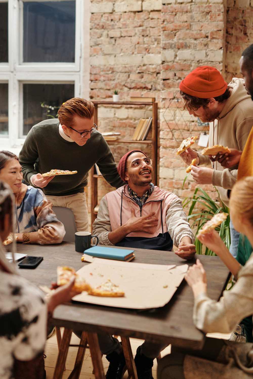 A Group of People Eating Pizza while Having Conversation