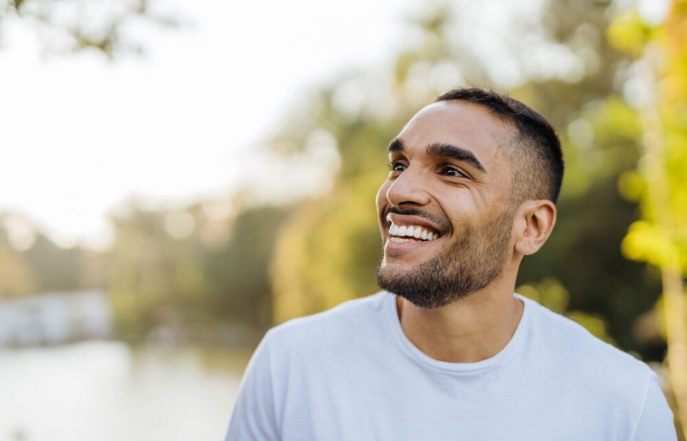 portrait of a young, happy man looking off to the side